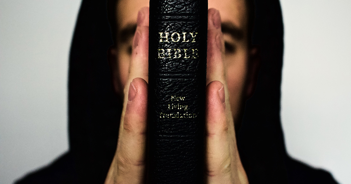 https://media.ascensionpress.com/wp-content/uploads/2018/09/man-in-hood-holds-up-bible.jpg